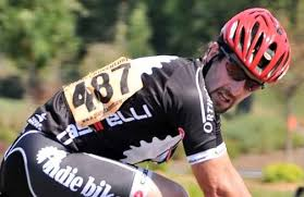 Cyclist with race number 487 pinned on the lower right side of the back